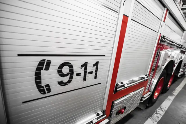 The side of a fire engine with a 9-1-1 decal on its compartment door